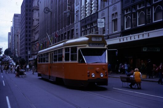 Eastbound in Bourke Street traveling through the trail pop-up temporary Bouke Street Mall on route 96 to "E. Brunswick".  This photo in late 1973 show the first changes to the tram with the brown painted skirt. 