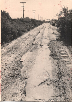 Road surface after removal of the rails showing broken sleepers and very poor rough roadway.