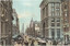 A bustling Victorian-era street scene looking west down Collins Street in Melbourne, Australia, featuring ornate stone buildings with large windows, horse-drawn carriages, cable trams, and pedestrians.