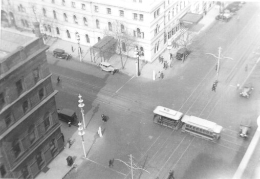 Menzies Hotel and the Goldsborough & Mort Woolstore with a cable tram crossing William Street in Bourke Street.