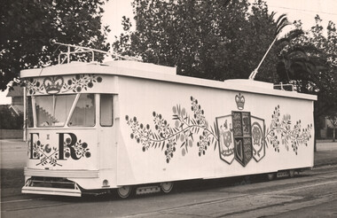 A white tram decorated with the royal coat of arms, floral patterns, and "ER II" insignia.