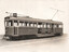 A vintage tram numbered 670 and labeled "CITY" is shown from the side. The tram has multiple windows and doors and is equipped with a trolley pole.