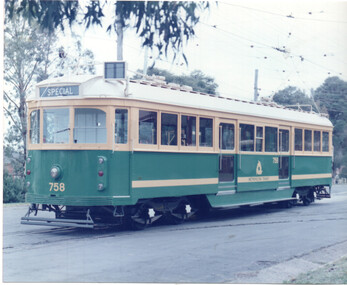 A green and cream tram numbered 758 with the word "SPECIAL" displayed on its front, displayed on a paved track.