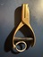 A brass single-hole punch with a spring mechanism and a looped handle, marked with "G144".