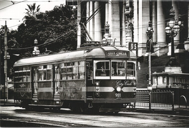 A vintage "City Circle" tram with the number 981 displayed, stopped on a city street in front of ornate classical architecture.