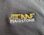 Embroidered logo on dark fabric featuring stylized yellow and white text "TMF MAIDSTONE." The logo combines bold yellow letters with a white vertical text element, indicating branding or affiliation with Maidstone location.
