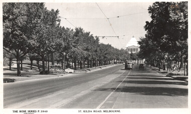 Showing a tree-lined street with a tram and cars, leading to a grand classical building in the distance.