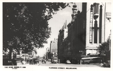 Black and white vintage photograph of a bustling city street with vintage cars and a tram. A large tree partially shades the left side of the image, with its branches extending over the street. The right side features ornate architecture, including a building with "PHANTOM OF THE OPERA" prominently displayed vertically. The street is lined with multi-story buildings and shows activity with vehicles and a tram in motion. The bottom text reads "FLINDERS STREET, MELBOURNE."