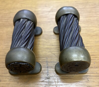 Two antique brass memotos with twisted steel cables with rounded caps.