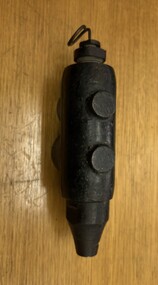 A black metal object with two rounded loops on the left side and a tapering point on the bottom.
