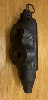 A black metal object with two rounded loops on the left side and a tapering point on the bottom.