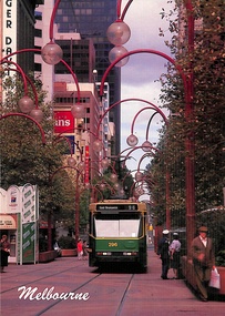 A tram traveling down a city street lined with unique red archways adorned with glass globes.