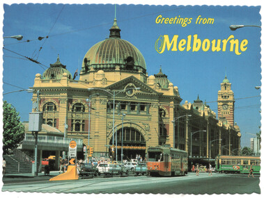 A postcard view of Flinders Street Station in Melbourne, Australia, with a tram in the foreground and cars on the street.