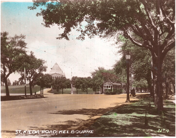 Vintage image of St. Kilda Road, Melbourne, with a green tram approaching a large domed building in the distance.