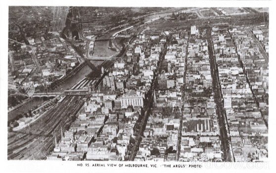 Aerial view of Melbourne, Victoria, showing a dense cityscape with a river and railway lines.