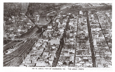 Aerial view of Melbourne, Victoria, showing a dense cityscape with a river and railway lines.