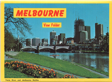 Scenic view of the Melbourne skyline and Yarra River with a bridge in the foreground and a park with flowers.