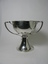 A silver trophy with two visible angular handles.