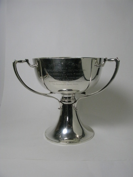 A silver trophy with two visible angular handles.