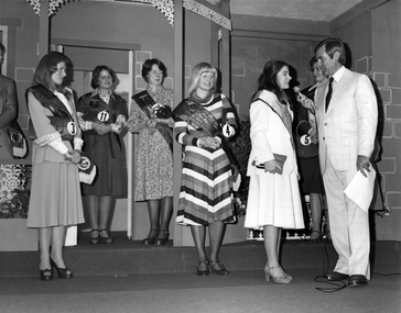 Brian Naylor interviewing a Show Girl contestant while others watch on from behind.