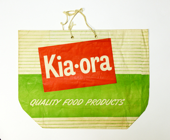 A Kia Ora showbag - paper bag with string handle, the brand name in bold white lettering in a red rectangle, against white and green stripes