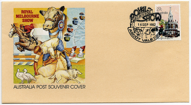 An envelope with artwork of a bull with a rosette, a showjumper, someone sheering a ram, poultry, a dog, a clown game, and a ferris wheel. A postage stamp with a building and a printed stamp are in the top right corner.