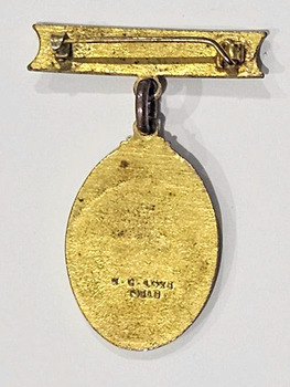 The reverse of a badged with an oval shape hanging from a bar.