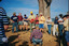Colour photograph depicting twelve members of Wooragee Landcare Group or local community members watching a kneeling man attend to a trap. 