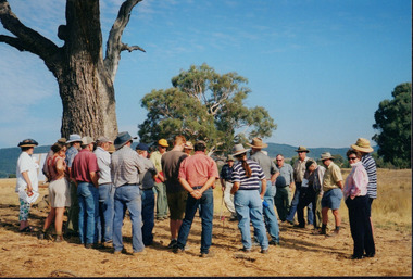 Colour photograph depicting approximately twenty-one people gathered around a speaker at a Wooragee Landcare event. 