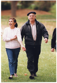 COL medium close up photo of two people within a small group, walking in a park.