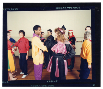 COL photo proof of a small group of people dancing in pairs. Many are dressed in traditional costumes. One woman is wearing a sweatshirt with the text "Move It Or Lose It" and a logo printed on the front.