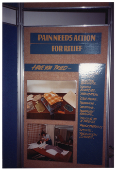 COL photo of one panel from a large freestanding display board. Under the heading, "PAIN NEEDS ACTION FOR RELIEF" is the sub-heading "HAVE YOU TRIED-", followed by a list of suggested actions. These include: electric blankets, gentle exercise, medication, cold packs, massage, resting, support groups, talking to a friend, physiotherapy, splints, and relaxation classes. The first two or three items on the list are obscured by a patch of reflected light shining on the photo image. There are also two photos on the display panel. The first is a photo of various heating aids such as mittens, a blanket and electric blanket, and a hot water bottle. The second photo someone lying on a treatment bed while receiving treatment from a practioner.