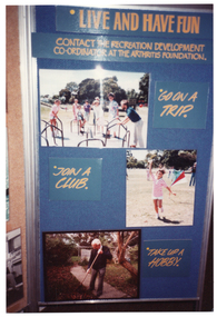 COL photo of one panel of a large freestanding display board. The panel is titled, "LIVE AND HAVE FUN", with the sub-heading, "CONTACT THE RECREATION DEVELOPMENT CO-ORDINATOR AT THE ARTHRITIS FOUNDATION." Below the headings, there are three photos positioned around the panel, each with some text next to it. The first photo depicts a group of children on some playground equipment, with the accompanying title card, "GO ON A TRIP". The second photo depicts a girl flying a kite, with the accompanying title card, "JOIN A CLUB". The third photo depicts an elderly man raking some leaves in the garden, with the accompanying title card, "TAKE UP A HOBBY".