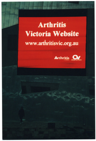 COL photo of a large electronic advertising billboard on the side of a tall building, at dusk. The billboard displays white text on a red background. The text is, "Arthritis Victoria Website www.arthritisvic.org.au", with the respective text and logos for 'Arthritis Victoria' and 'Osteoporosis Victoria' below that.