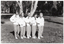 B&W photo of a five women posing for a photo in a park. They are standing close to one another in a line, at a 45 degree angle, with one hand on one hip. They are each wearing a sweatshirt printed with the "Joint Action" logo.  There are several trees in the background, with one very large tree directly behind them.