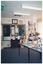 COL photo of various displays in a large room. There are posters on the wall and around a window. Booklets, brochures, and leaflets are laid out on two tables and a display board. There are also decorations, such as paper skeleton cut-outs hanging from the ceiling.