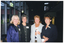 COL photo of four women posing for a photo outside a building at night. The building has tall floor to ceiling glass wall panels, and there is an "EXIT" sign above a double glass door.