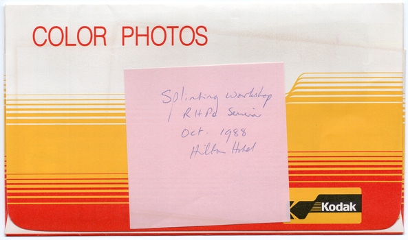 COL digital scan of a red, yellow/orange, and white Kodak photo envelope with the heading “COLOUR PHOTOS” in red text at the top of the flap, and the Kodak logo in the bottom right hand corner of the flap. There is a handwritten pink sticky note stuck to the top of the flap.