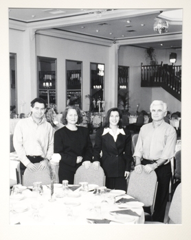 4 people posing for a photo at a restaurant. 