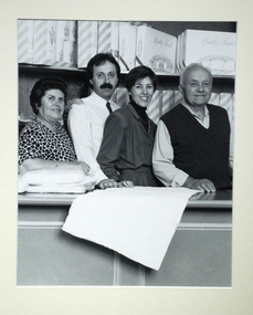 4 people posing in a shopfront.