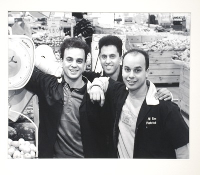 3 men smiling in a grocery store. 
