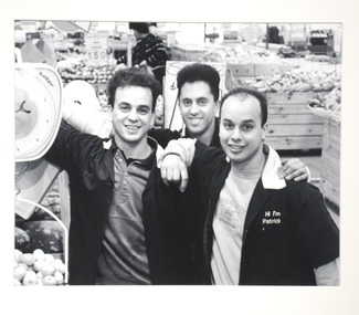 3 men smiling in a grocery store. 
