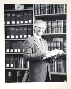 Portrait of a man holding a book. 