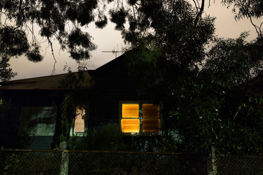 Photograph of a house with lights on at night time