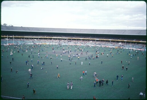 A photograph of a football field with fans on it.