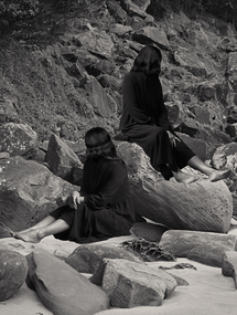 Black and white photomontage of two women sitting on rock.