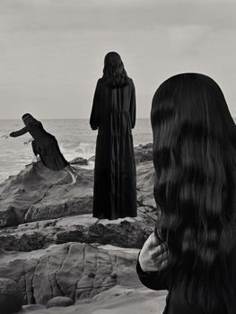 Black and white photograph of three women on the shore of a beach