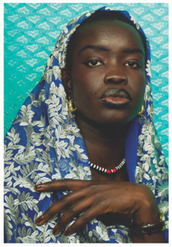Photographic portrait of Nyanluak in front of teal patterned background.