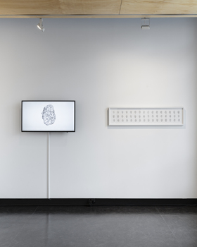 One the left is a TV screen displaying a drawing of a rock like object. On the right is a rectangular framed print of similar rocks in a 3 x 16 grid. 