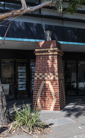 A brick sculpture of a chimney in a suburban street